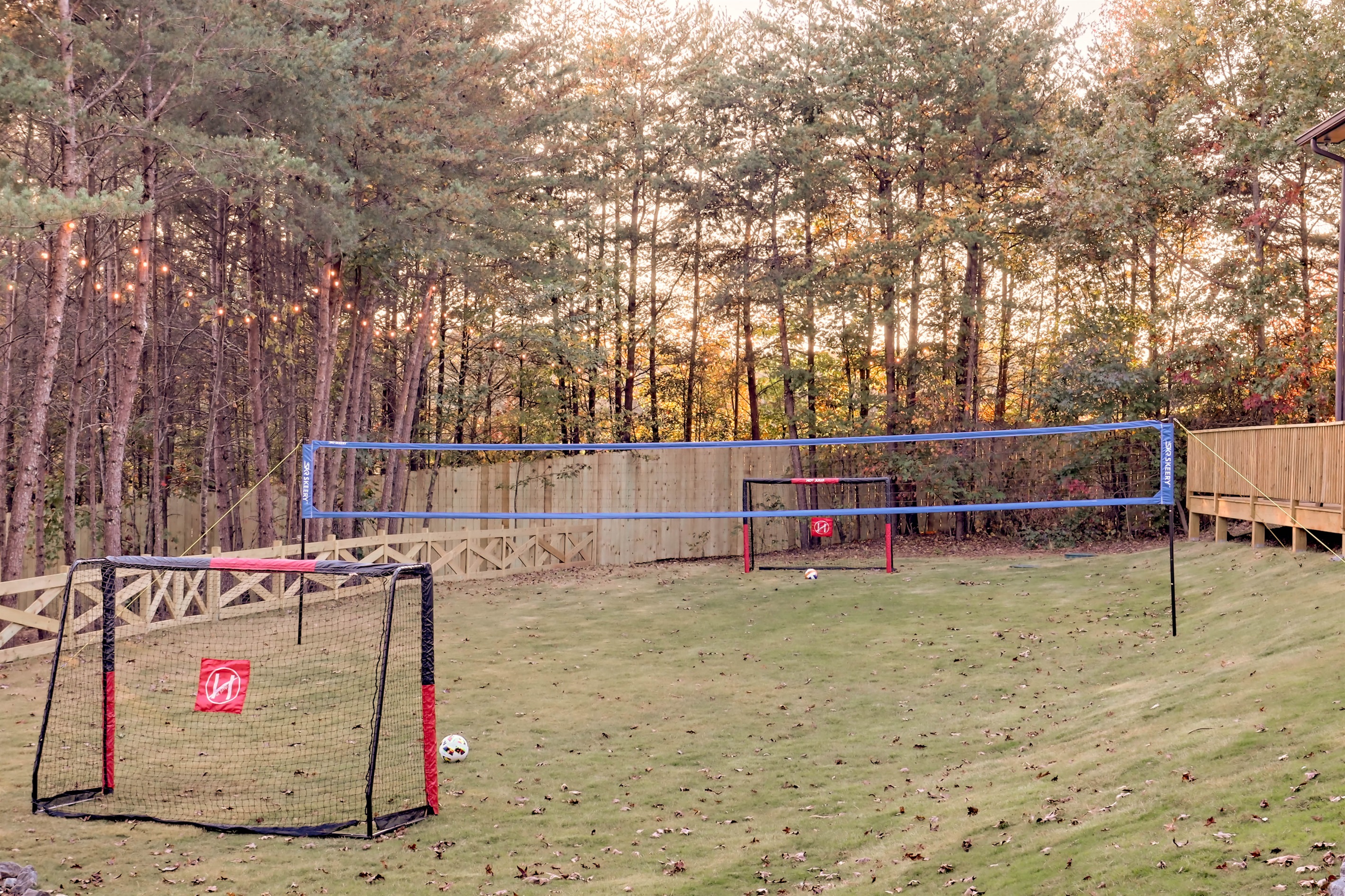 Large yard with soccer goals and a volleyball net for fun outdoor play.