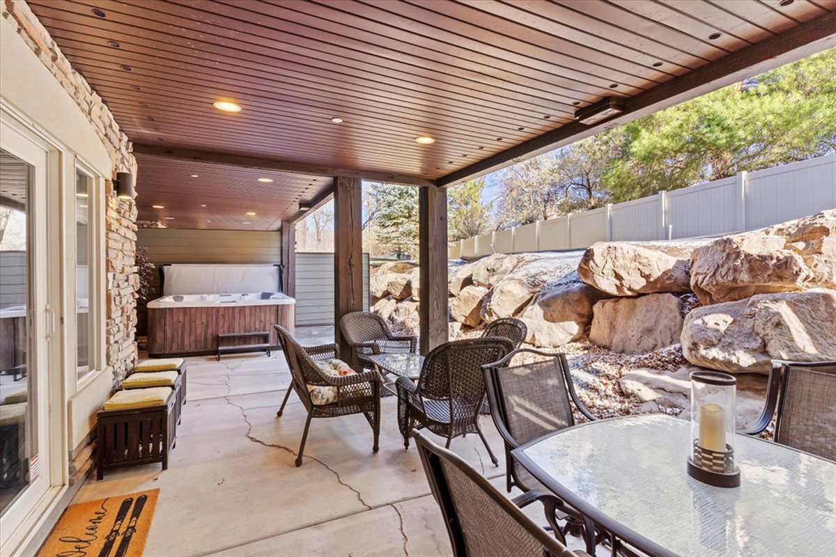 An extended outdoor living area with comfortable seating and rustic stone accents, creating a peaceful setting for gatherings or quiet moments.