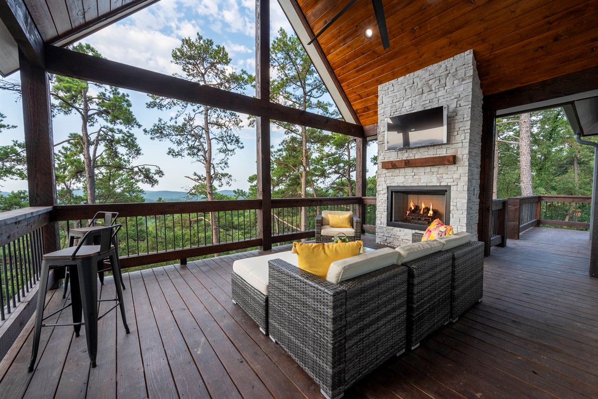 Outdoor lounge with fireplace and panoramic forest views for relaxing evenings