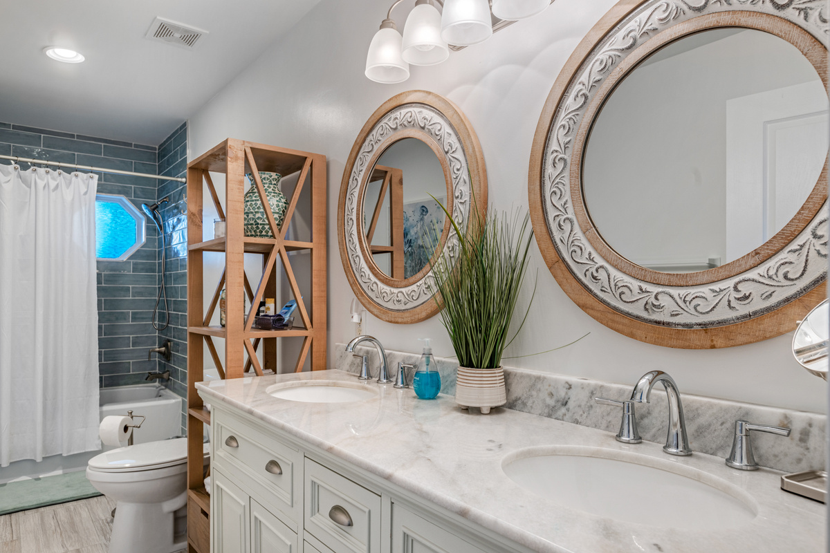 Primary ensuite bathroom with custom tiled shower/tub combo and double vanity.