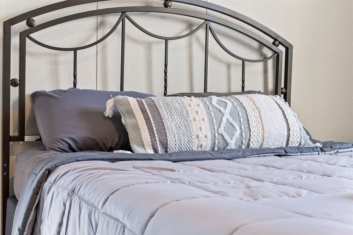 Plush bed with fresh linens and accent pillows—designed for comfort and relaxation.