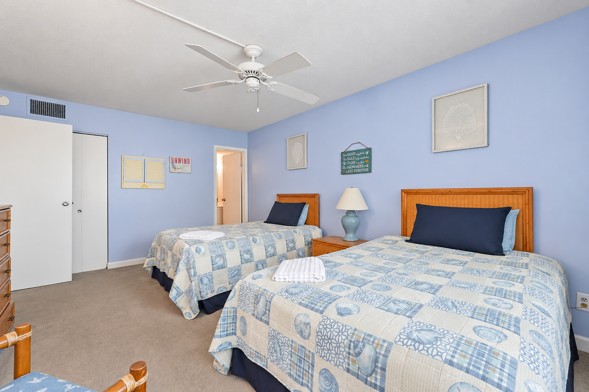 Second Bedroom with two full beds, ceiling fan, wide window view, and ensuite bathroom access.