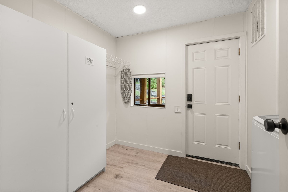 Guests enter through the laundry room, featuring fresh appliances and plenty of space for everyday essentials