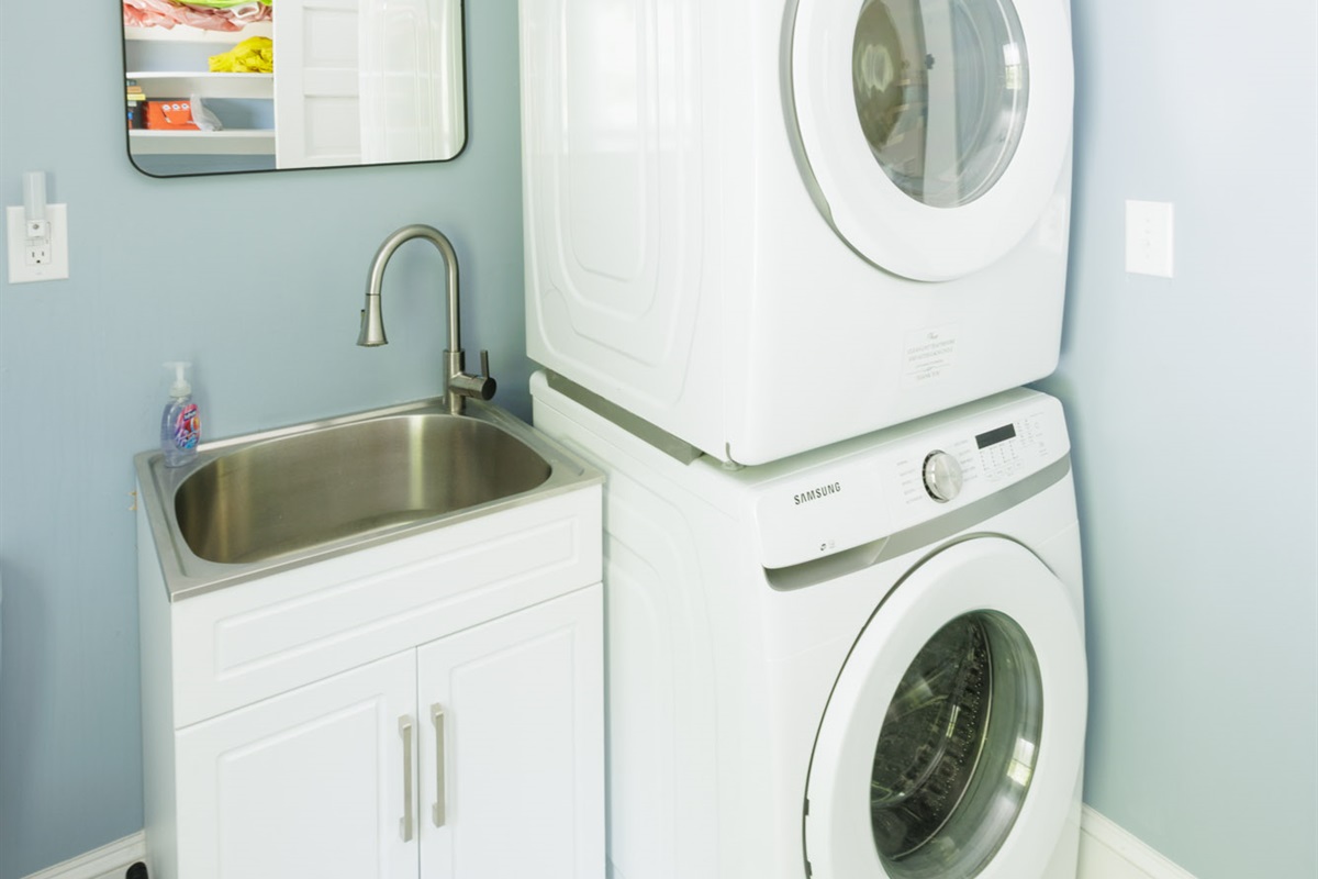 Laundry has a washer, dryer, and doubles as a half-bathroom with a toilet and sink.