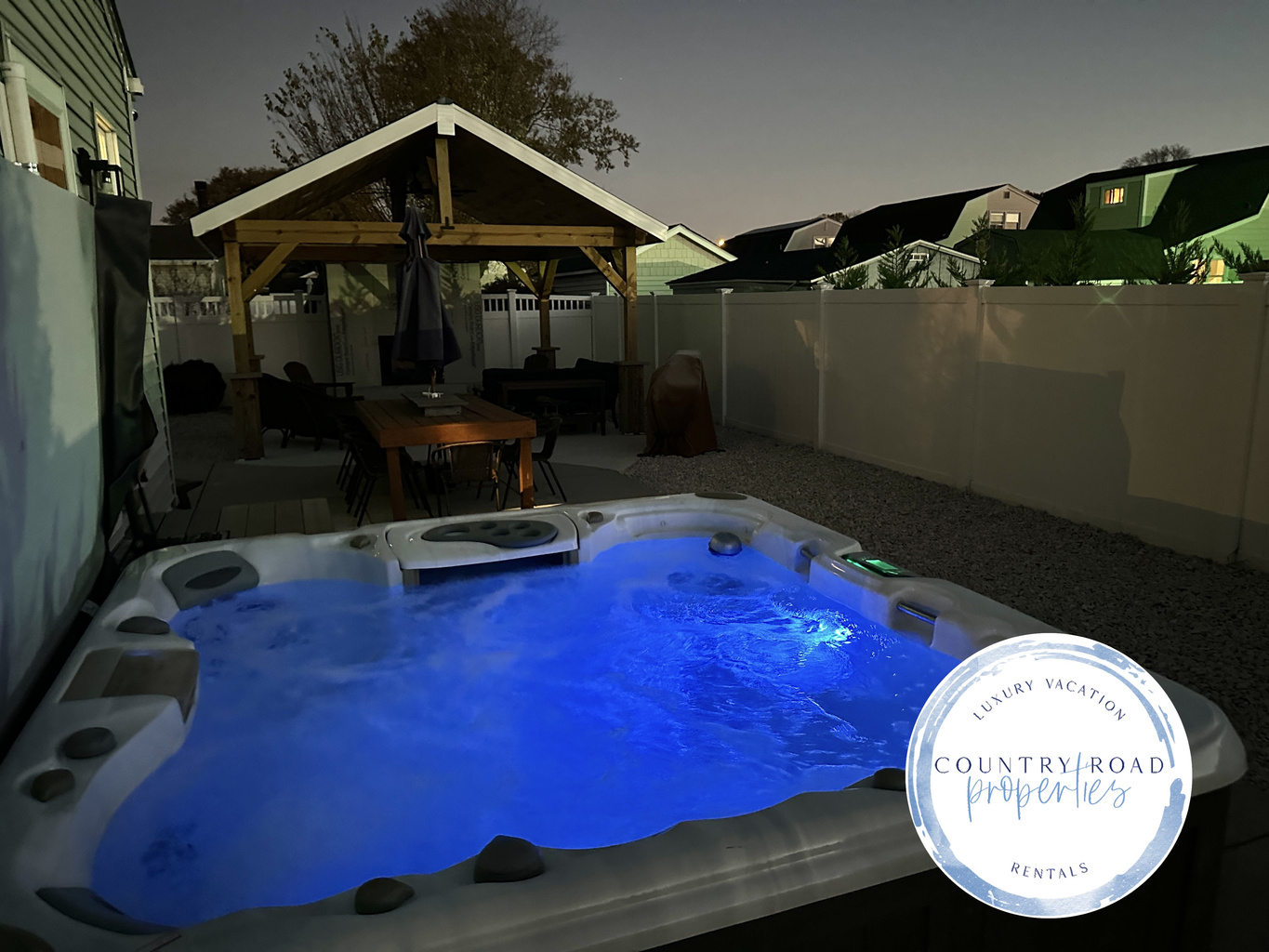 Indulge in ultimate relaxation under the stars in our glowing blue hot tub. This private backyard oasis features a spacious patio with a dining table and a covered lounge, perfect for soothing escapes during your vacation.