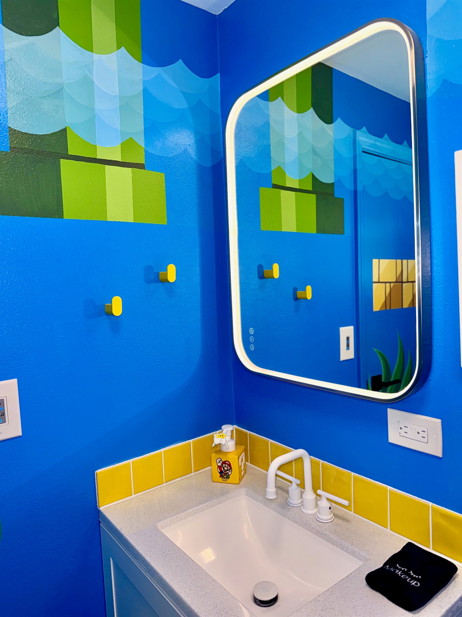 Custom mural and lighted vanity mirror in the bathroom.