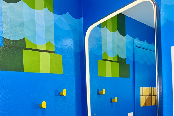 Custom mural and lighted vanity mirror in the bathroom.