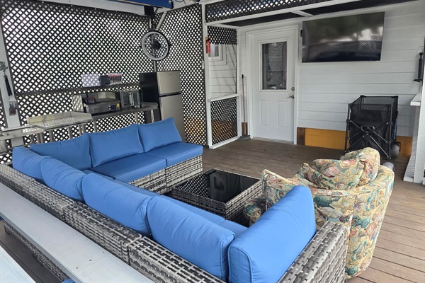 Comfy Seating, Large TV, fan and patio kitchen make the screened patio a great place to hang out.