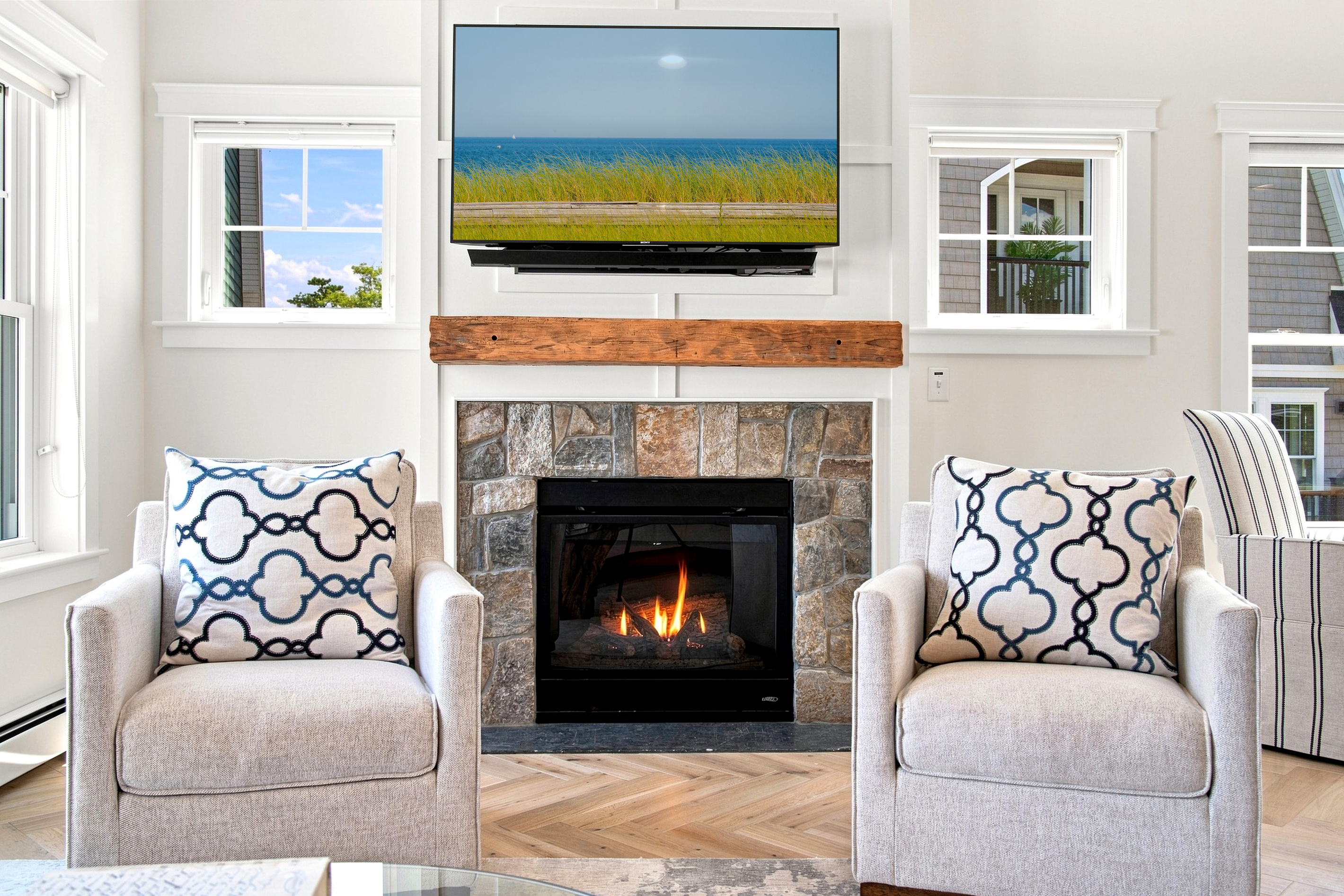 Cozy up by the fireplace after a day at the beach in this bright, inviting living space.