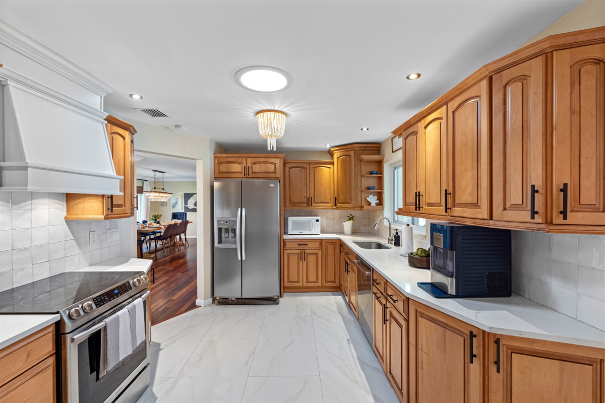 Stainless steel appliances pair beautifully with the natural wood cabinetry in this spacious and inviting kitchen.