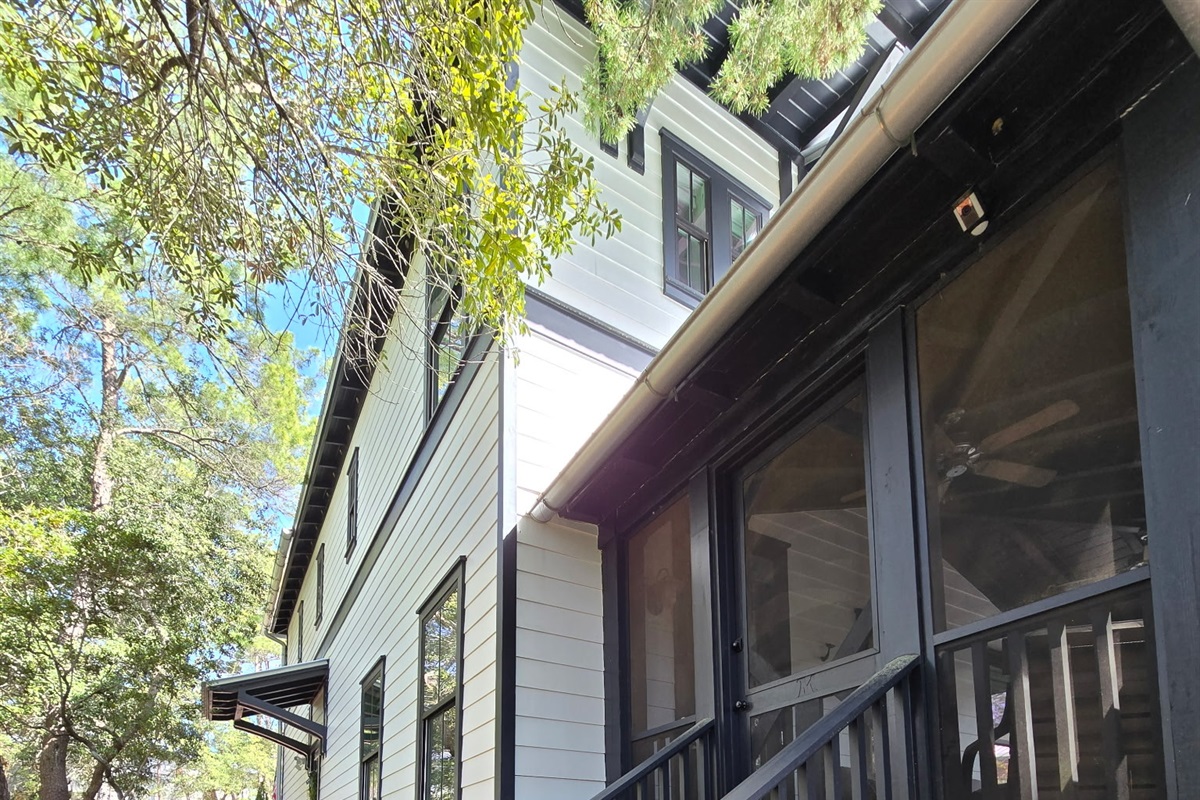 Step up to the inviting screened porch, framed by tall pines and natural landscaping. A charming entryway that blends modern cottage style with the peaceful beauty of the outdoors. ✨