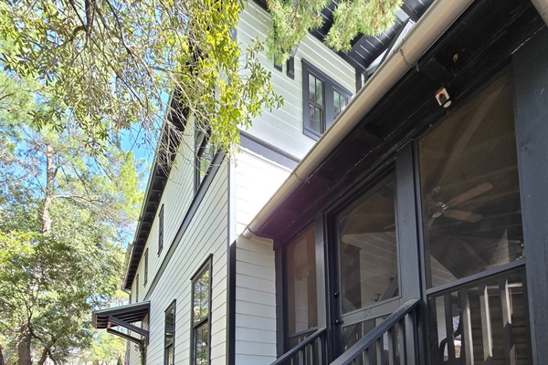 Step up to the inviting screened porch, framed by tall pines and natural landscaping. A charming entryway that blends modern cottage style with the peaceful beauty of the outdoors. ✨