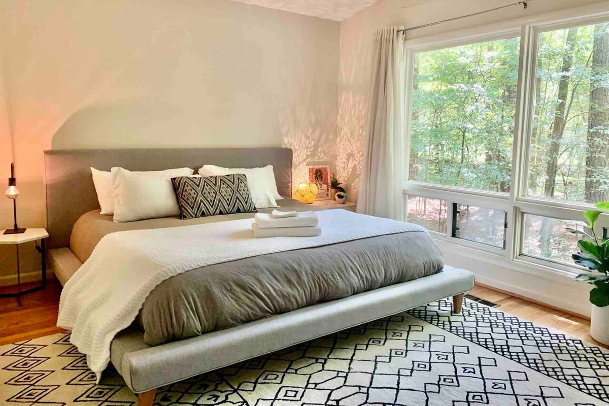 This bedroom also features a king size bed - this time on a West Elm platform bed frame. With spacious picture windows looking in to the backyard and a couch in this room for lounging, it's spacious and peaceful -- and perfect for napping!