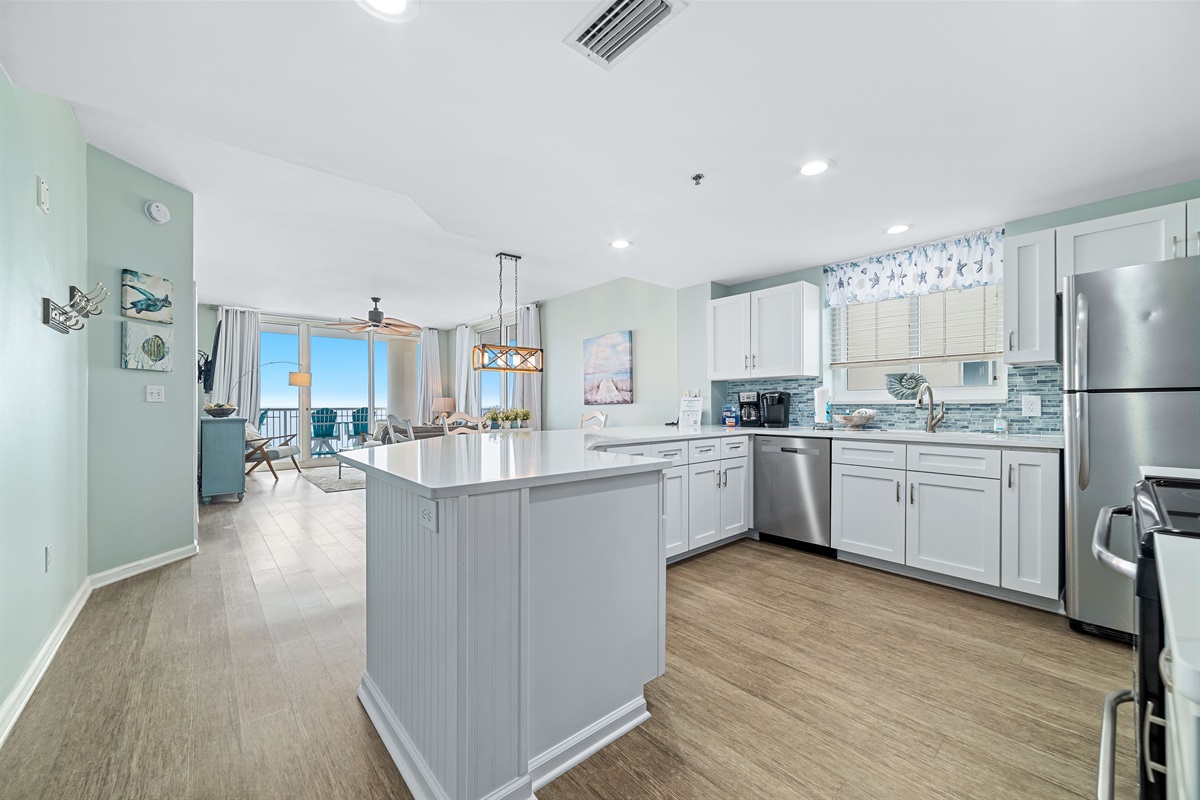 This bright, functional kitchen features white cabinetry, stainless steel appliances, and a seamless flow into the main living space. Enjoy the breathtaking Gulf view while brewing your morning coffee—it’s coastal living at its finest.