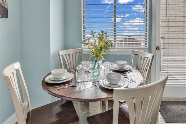 Round dining table set for 4 — perfect for meals with a view of the ocean outside