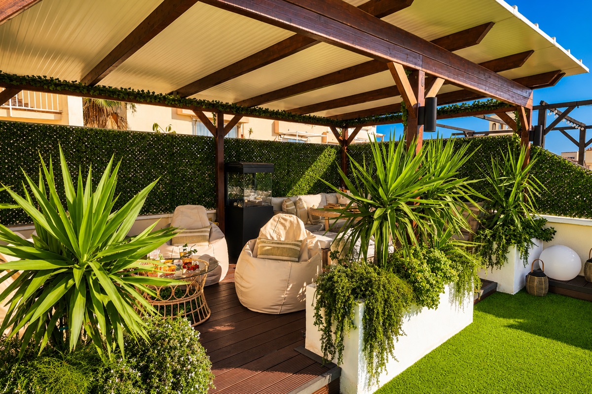 Relax beneath the covered pergola with cozy seating, fireplace, and dining area. Perfect for long evenings, romantic dinners, or movie nights on the outdoor TV under soft ambient lights.
