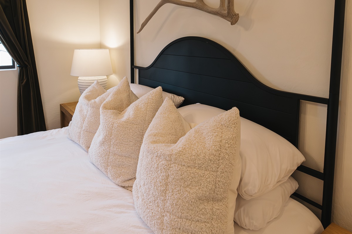 Serene king bedroom with plush linens, cozy pillows, and rustic mountain accents—designed for deep rest after hiking, skiing, or exploring Arizona’s White Mountains.