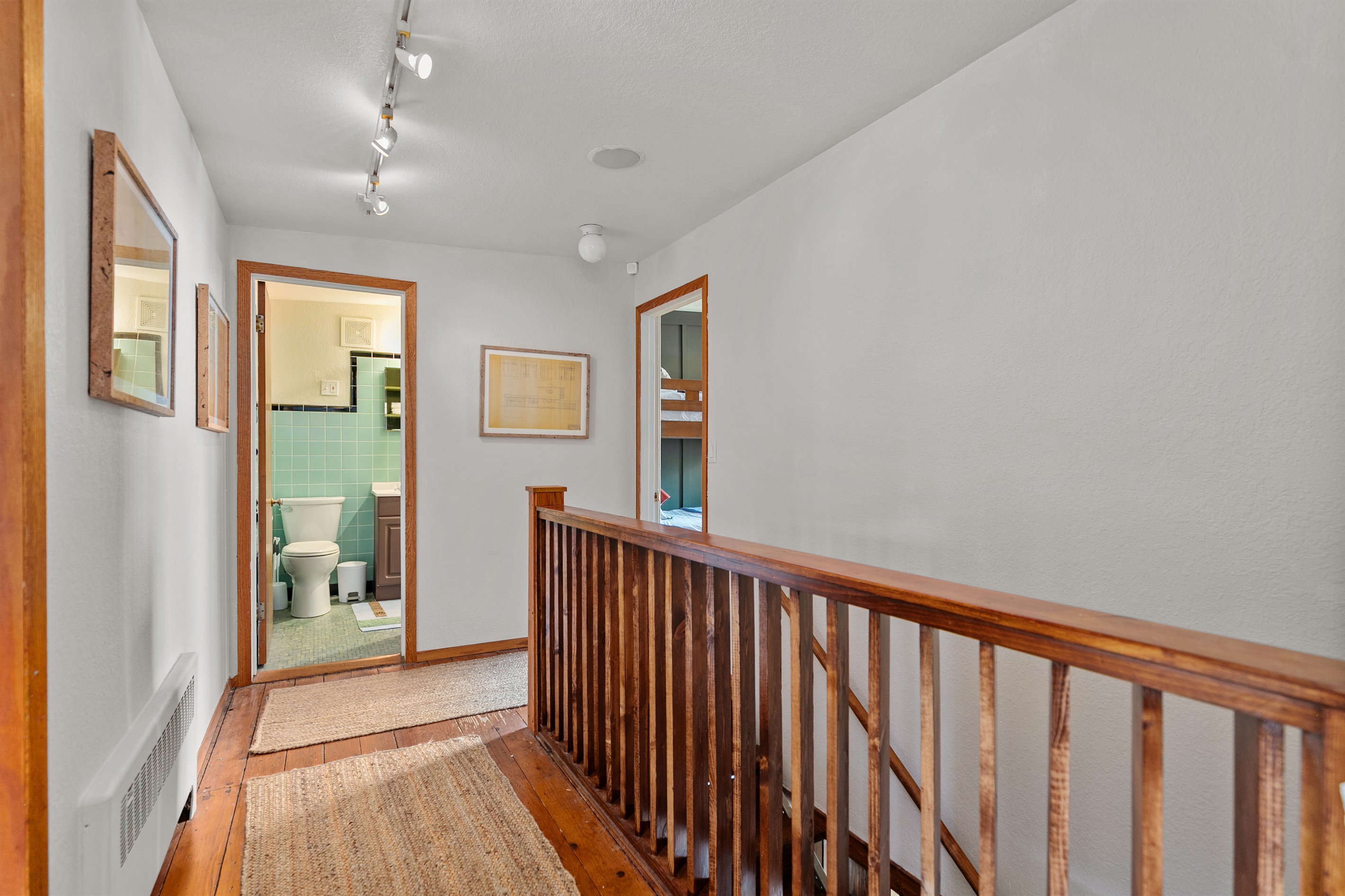 The hallway opens to a staircase leading upstairs, guiding you toward the home’s cozy bedrooms and private spaces.