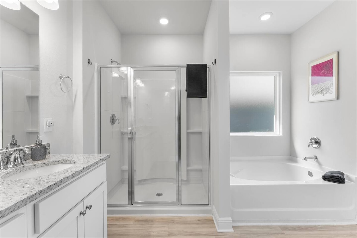 Spacious bathroom offering both a separate shower and a calming bathtub experience.