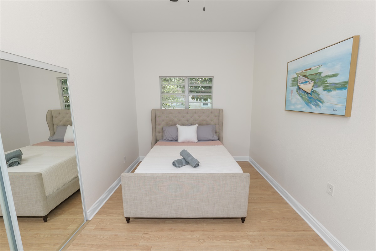 Soft tones, clean lines, and a wingback headboard create a bedroom that feels both upscale and welcoming.