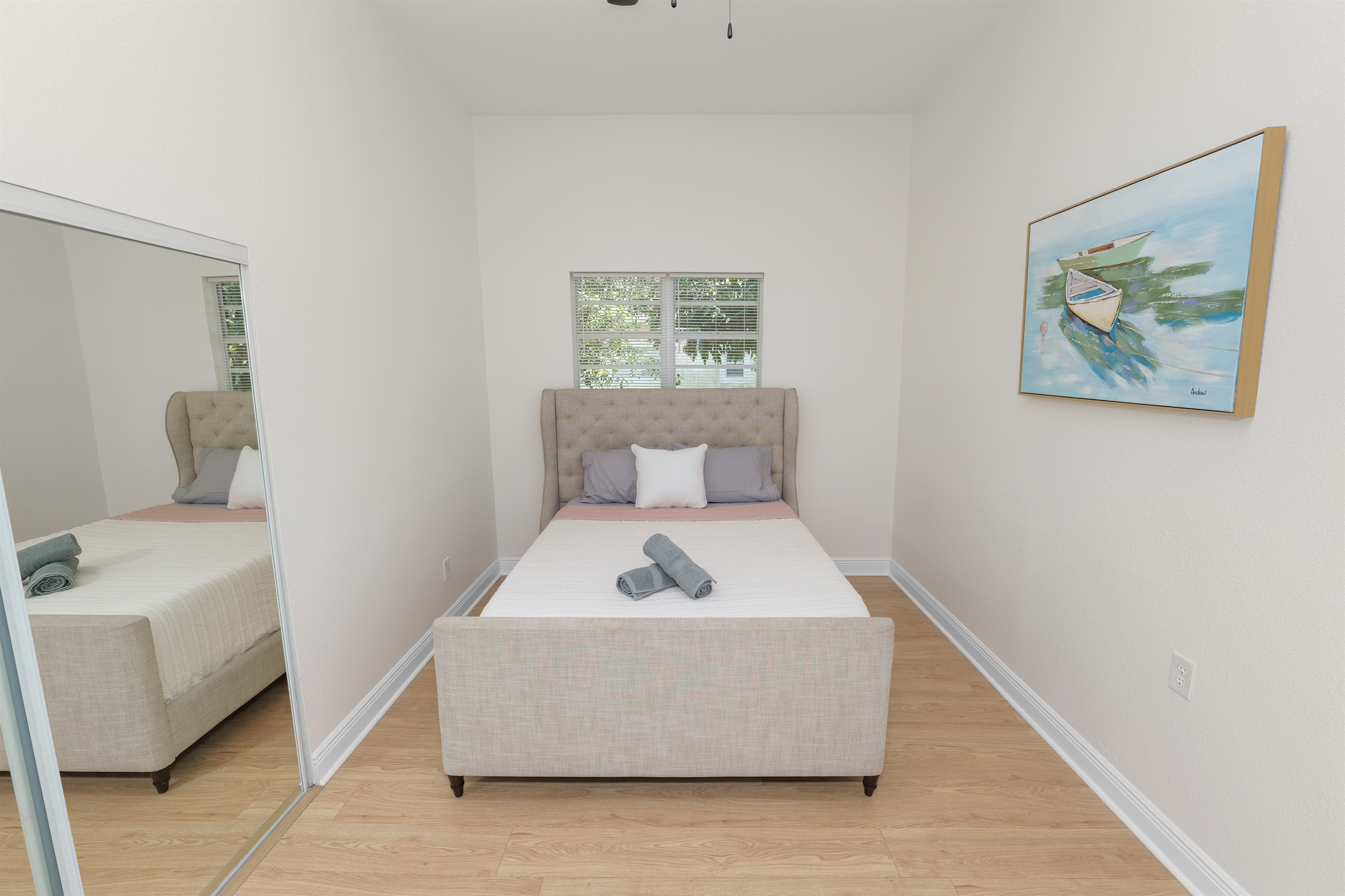 Soft tones, clean lines, and a wingback headboard create a bedroom that feels both upscale and welcoming.