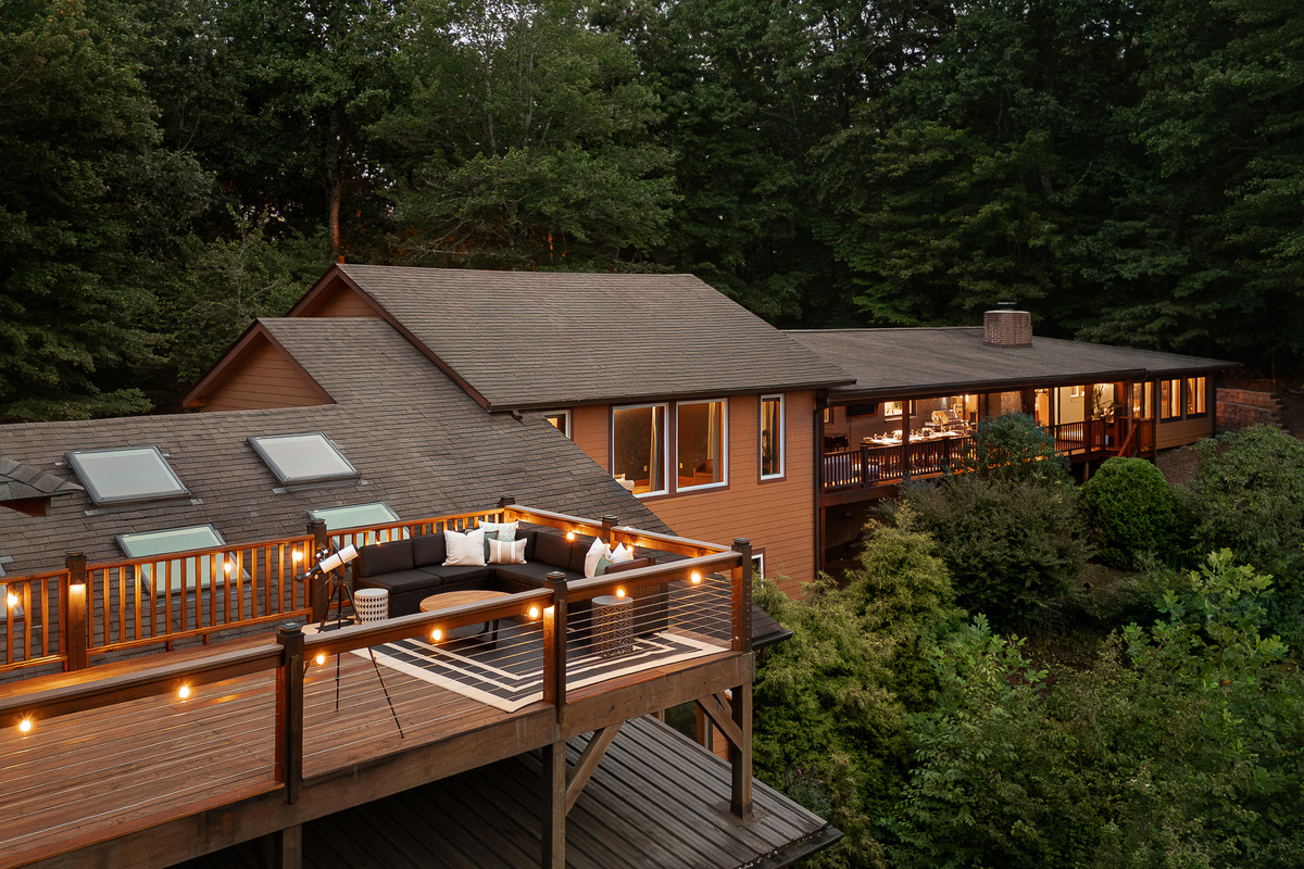 {Private Mountain Resort} Multiple decks cascade along the mountainside, creating plenty of outdoor spaces to gather, dine, lounge, and take in the forest setting.