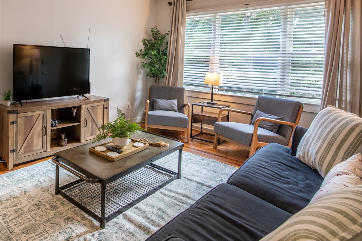 Another angle of the sunlit living space, showing comfortable seating, décor touches, and overall layout.