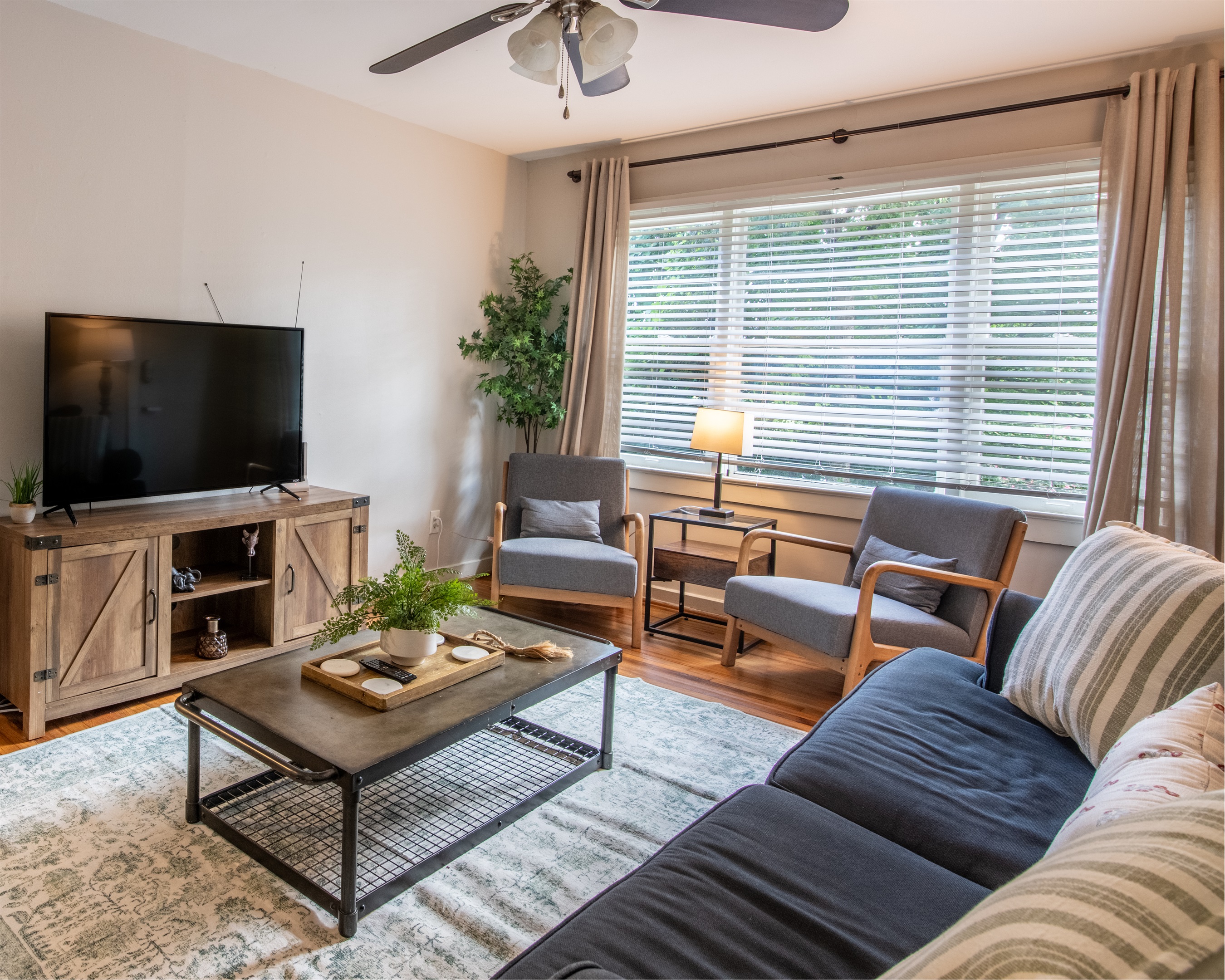 Another angle of the sunlit living space, showing comfortable seating, décor touches, and overall layout.