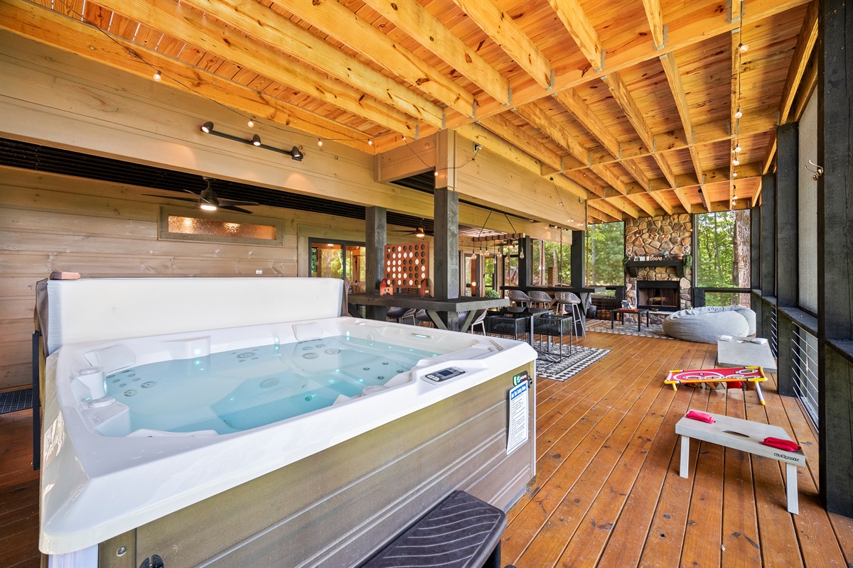 Soak, dine and unwind. This expansive covered deck features a private hot tub, cozy outdoor fireplace, dining space, and games, making it the ultimate mountain hangout spot.
