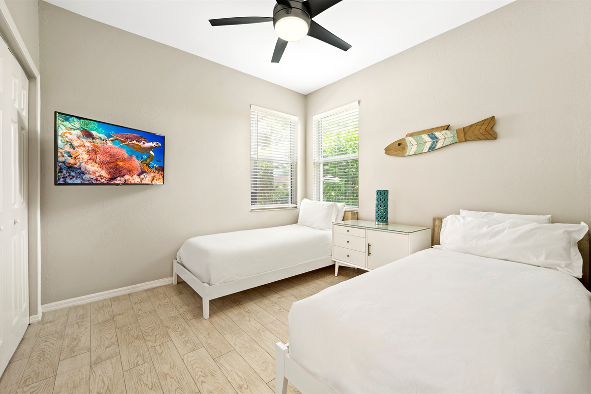 Twin bedroom features a TV, ideal for late nights