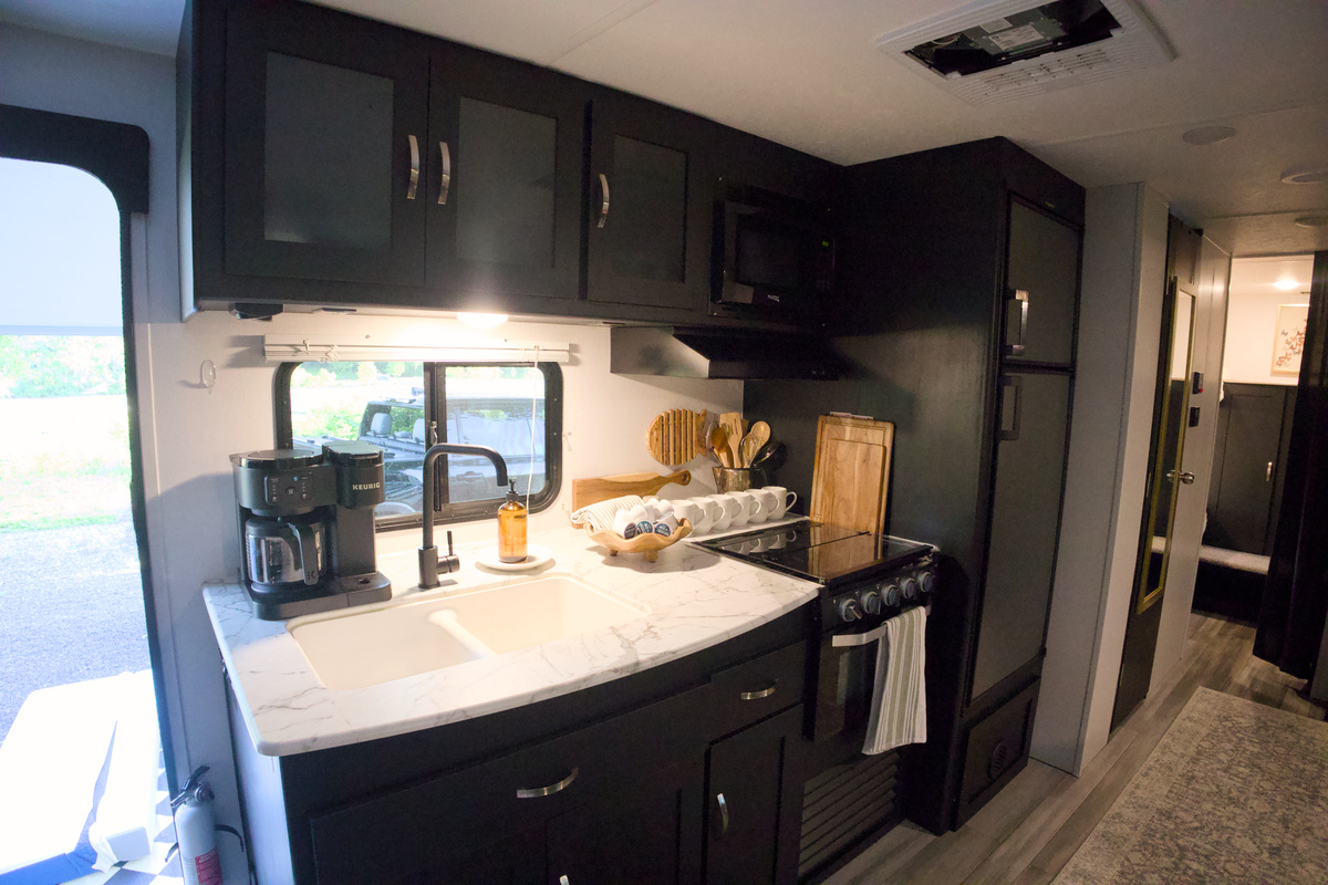 Kitchen area, fully stocked. Propane 3 burner stove. Camper sized fridge/freezer.