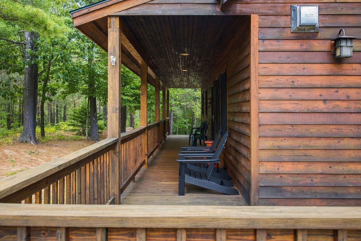 The covered porch offers a protected, shady spot to relax among the trees.