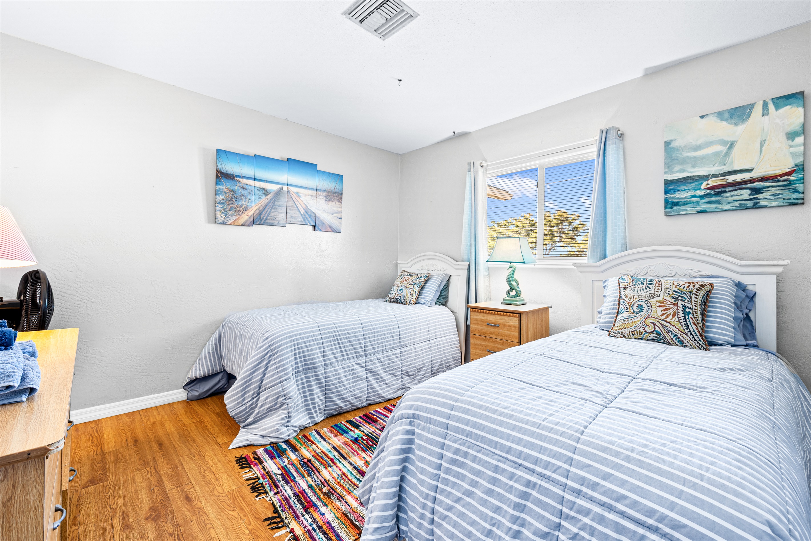 Sand Dollar Room with Two twin beds with linens, a dresser and two closets. 