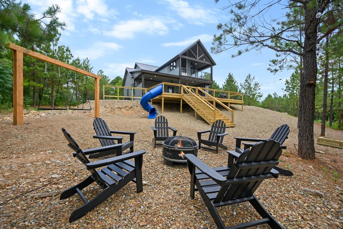 Backyard space with deck, slide, swings, firepit and horseshoe pit.