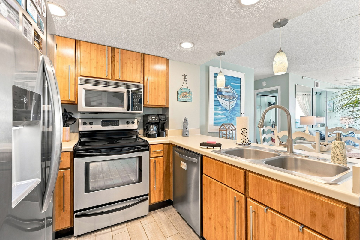 Fully equipped kitchen with updated stainless appliances, double sink, and plenty of room to whip up meals.