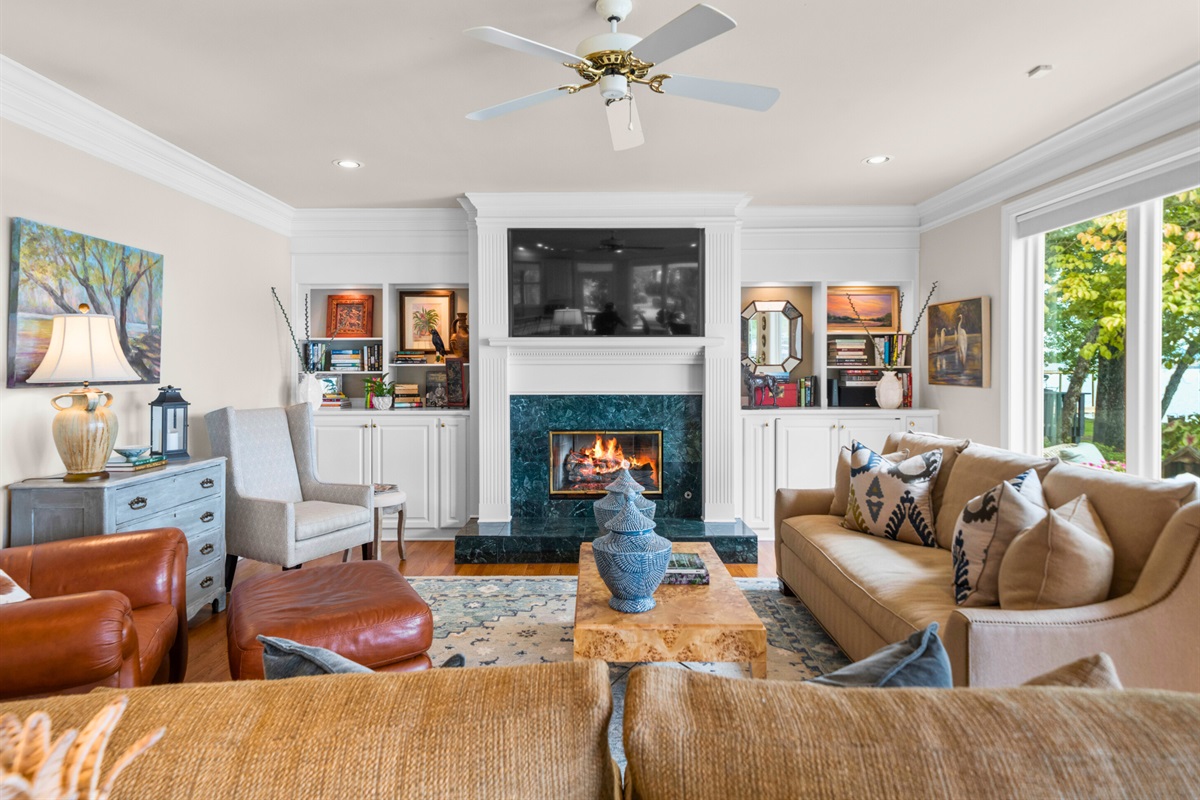 Gather around the fireplace in this bright, spacious living room filled with charm and natural light.