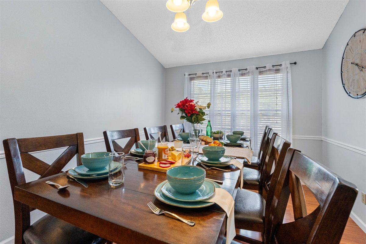 Enjoy meals together at this thoughtfully arranged dining table, complete with elegant settings and a centerpiece that adds a pop of color.