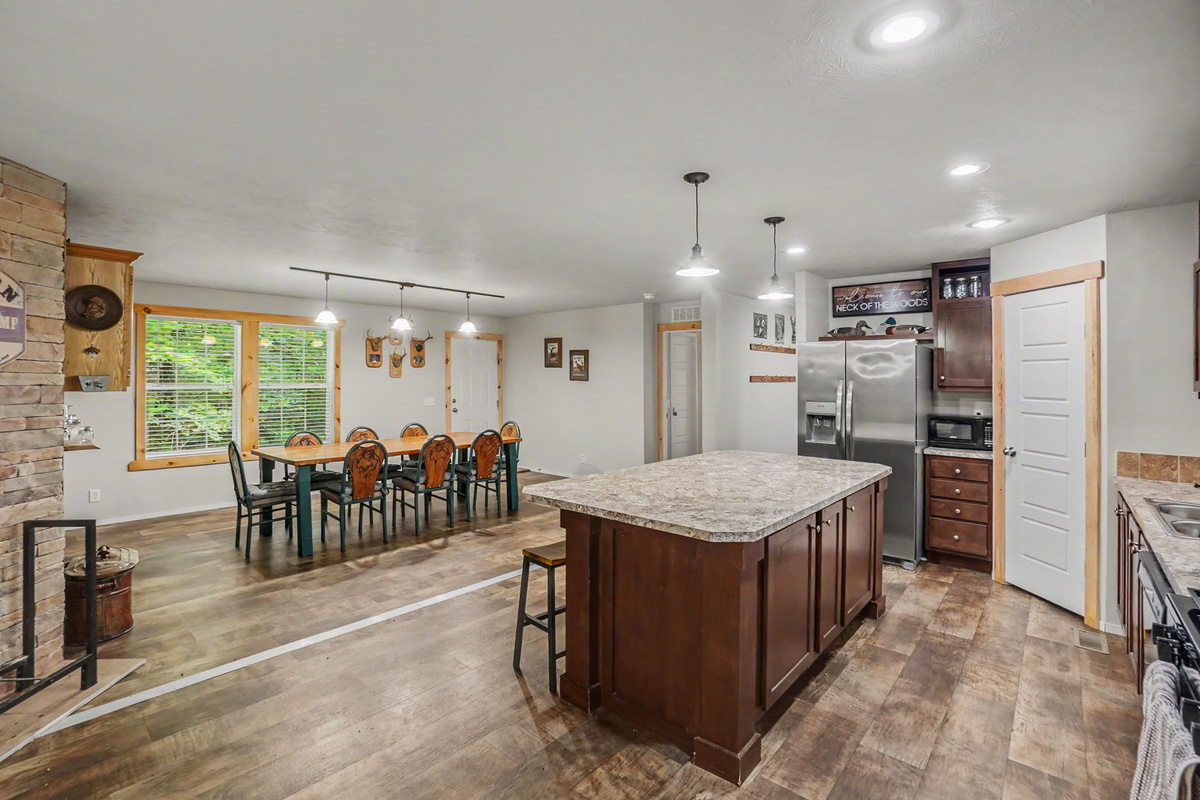 Kitchen with large island with bar stools and dining area.