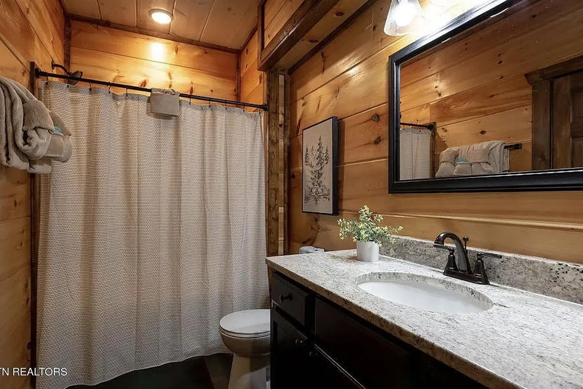 Marigold Cabin's first full bathroom is well-appointed and ready for your group, featuring modern fixtures and fresh, clean finishes. Having three full bathrooms in this Pigeon Forge cabin rental means no morning rush &mdash; everyone has the space and privacy.