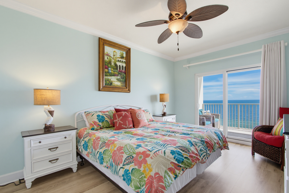 Primary king bedroom with private balcony access, Gulf views, and a TV.