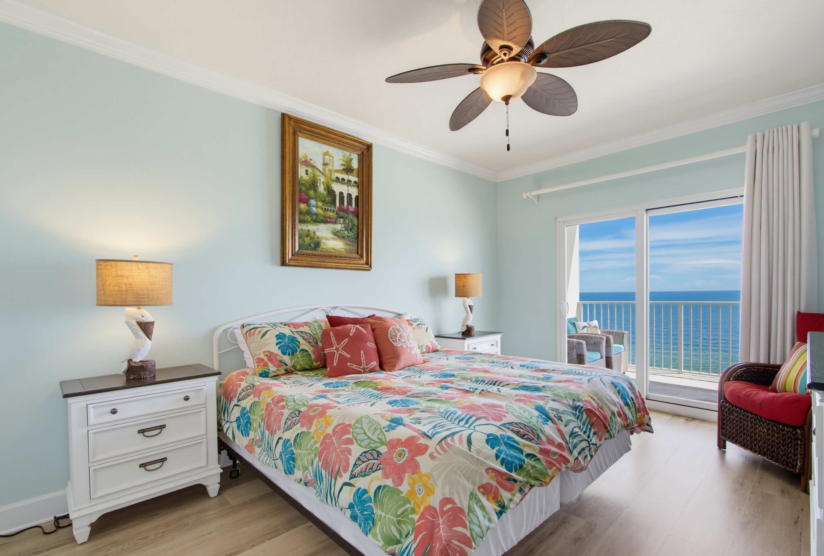 Primary king bedroom with private balcony access, Gulf views, and a TV.