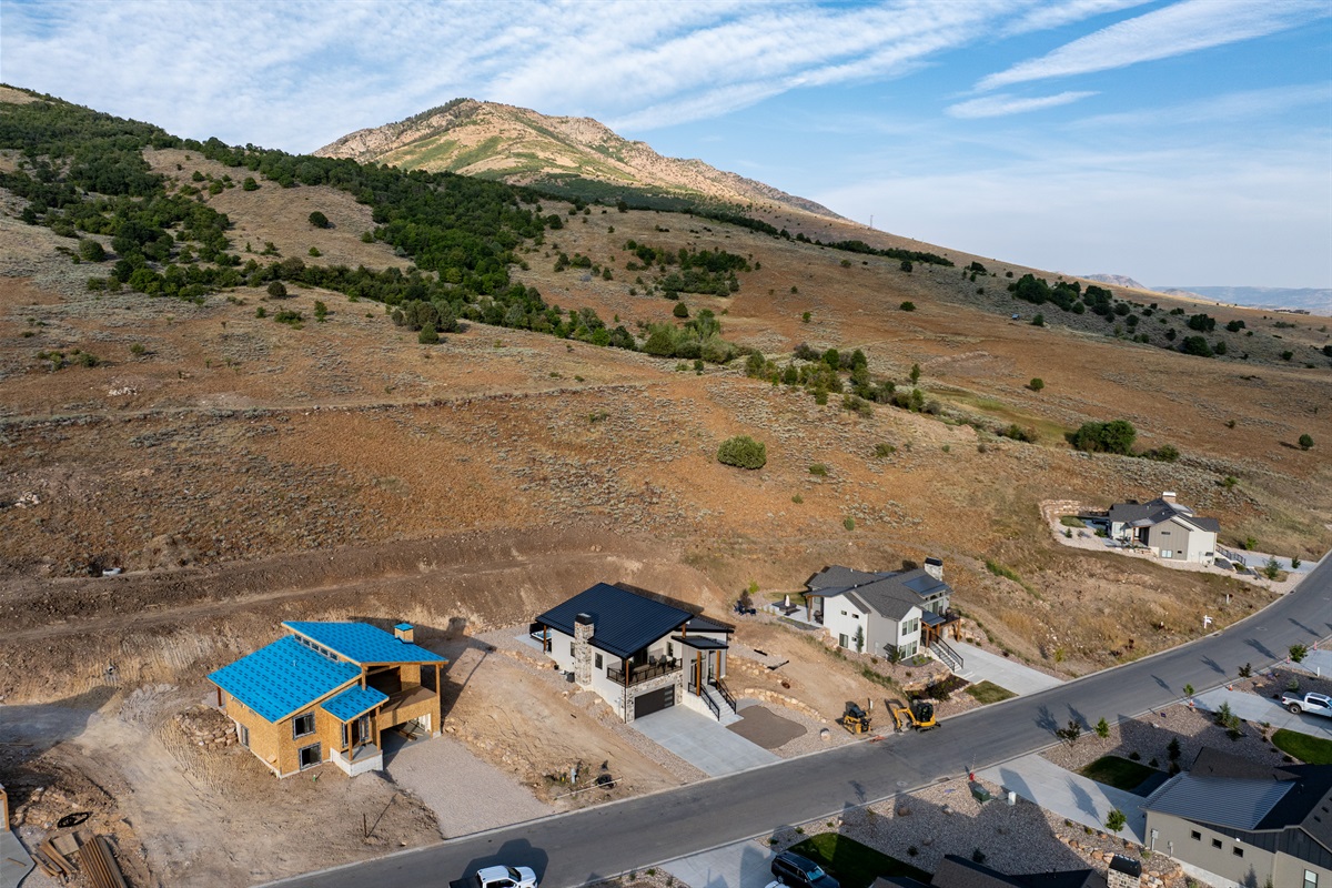 Drone view showcasing The Bridges development, surrounded by the rolling landscapes and mountains.