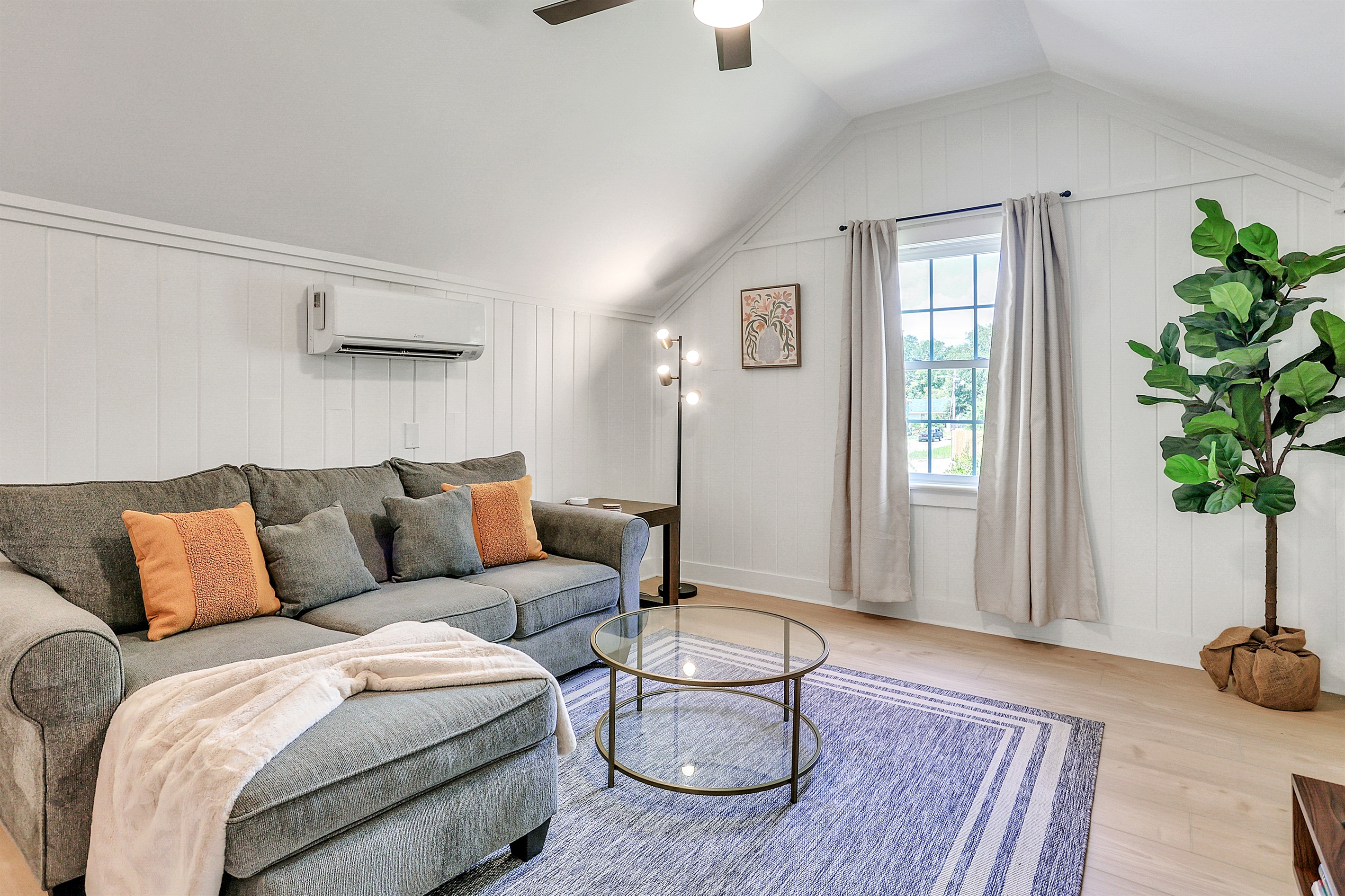 Tall ceilings and abundant natural light create an airy, inviting space—perfect for relaxing on the cozy sofa after a long day.