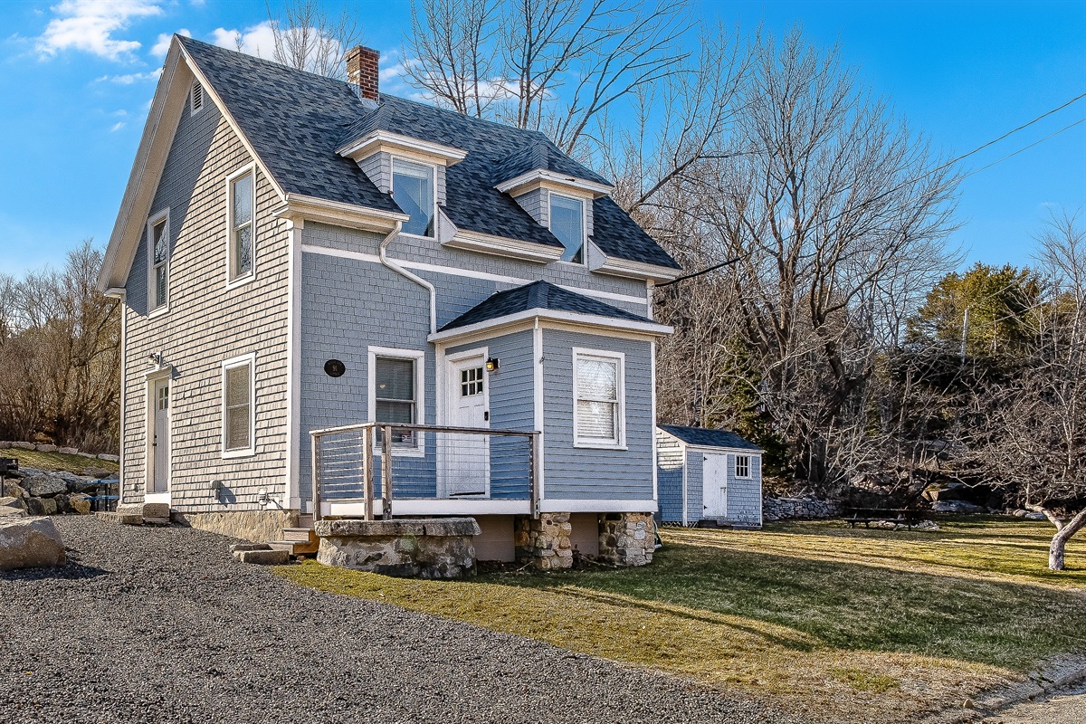 This driveway view shows the main entrance and mudroom—handy for dropping your boots after a hike. You can also see the side yard with the firepit, the perfect spot for roasting s'mores and planning your next trail under the stars.