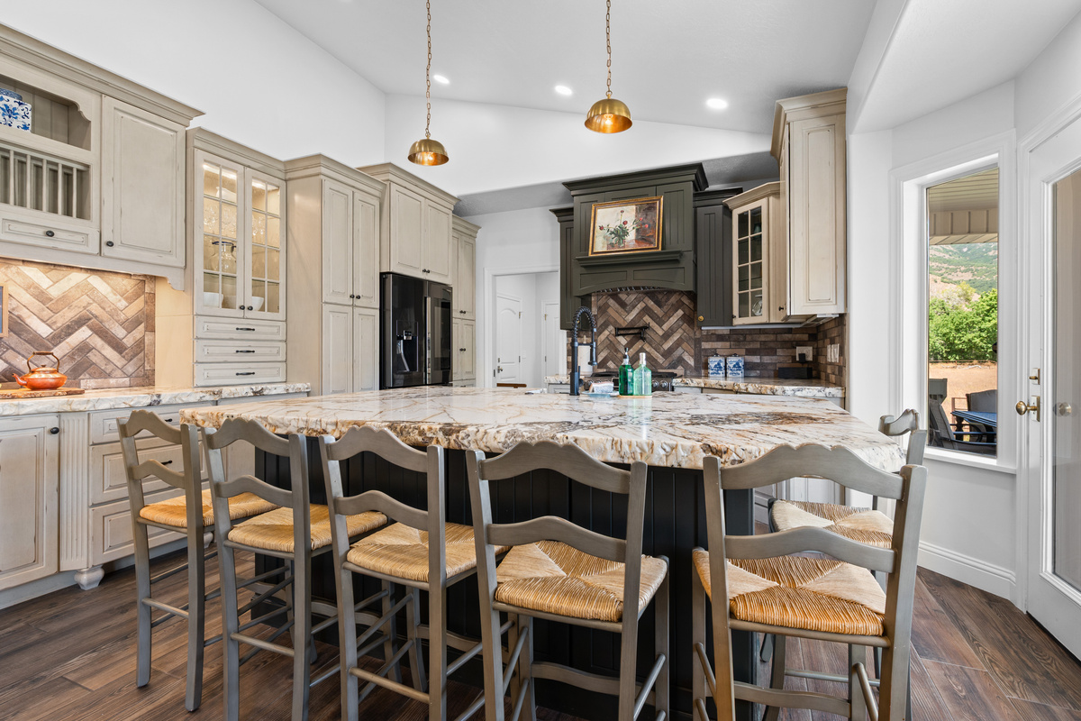 A grand island anchors the kitchen, offering generous prep space and bar seating for guests to gather while meals are prepared.