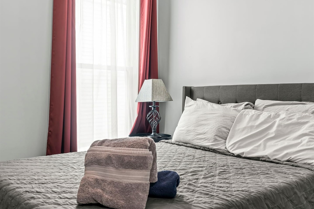 Close-up of the full-size bed with fresh linens and bedside lamp, creating a cozy sleep space.