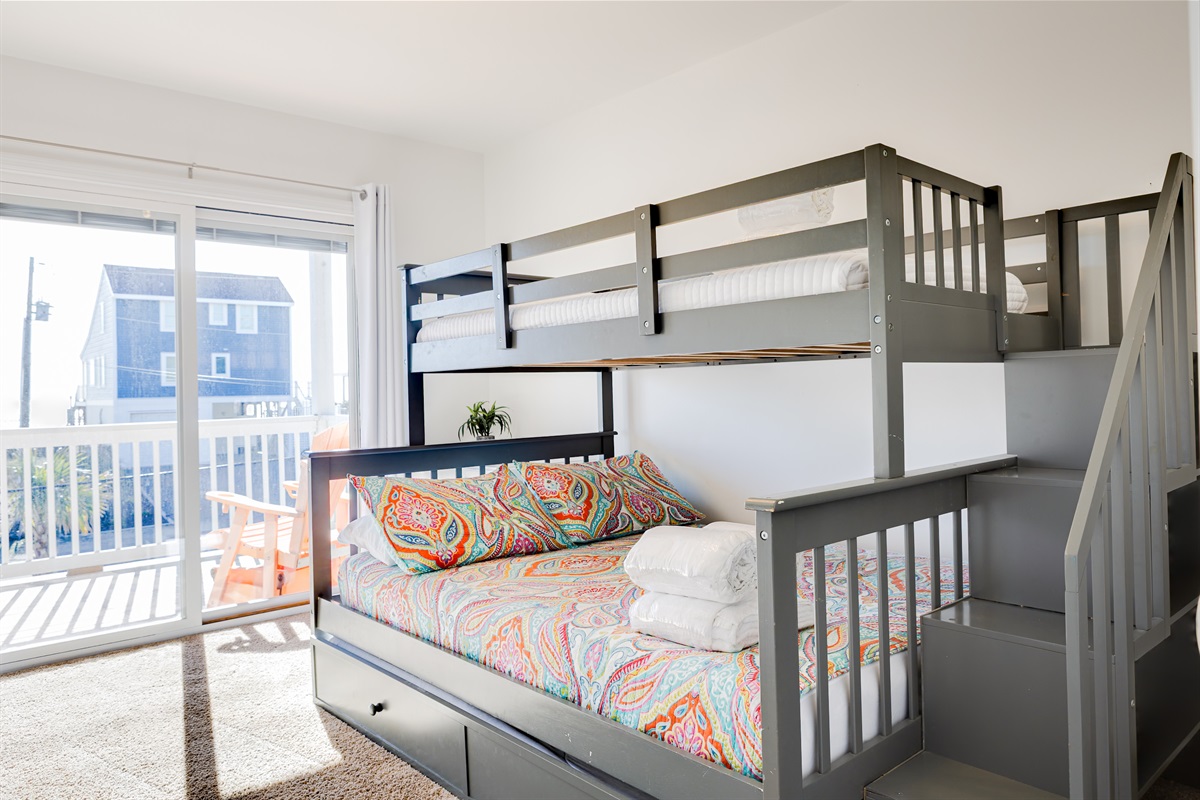 Fun and bright kids&rsquo; bedroom with bunk beds and colorful bedding, perfect for sleepovers, giggles, and cozy nights after beach adventures