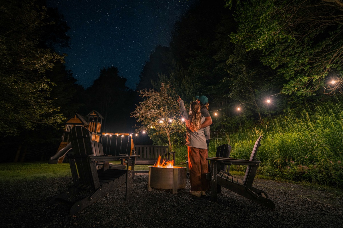 Starry night by the fire: a couple shares a moment under twinkling skies.
