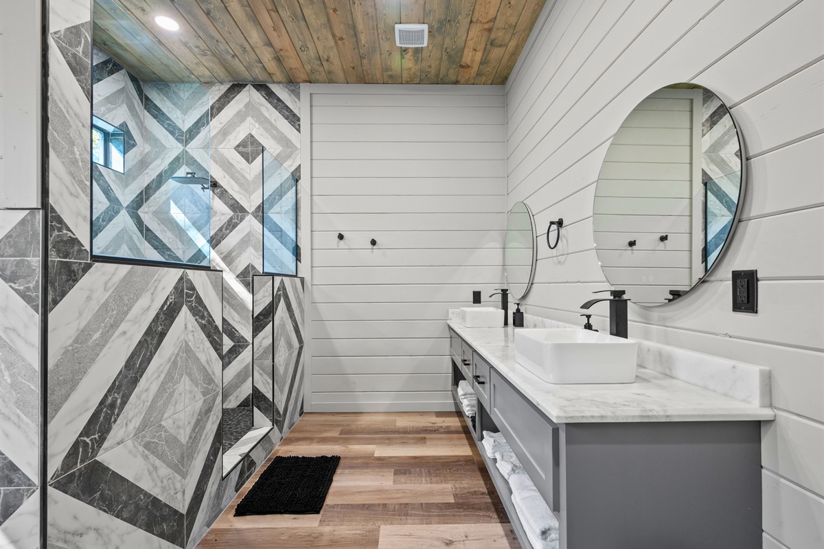 Double vanities, polished finishes, and soft lighting make getting ready a pleasure in this spacious bathroom.