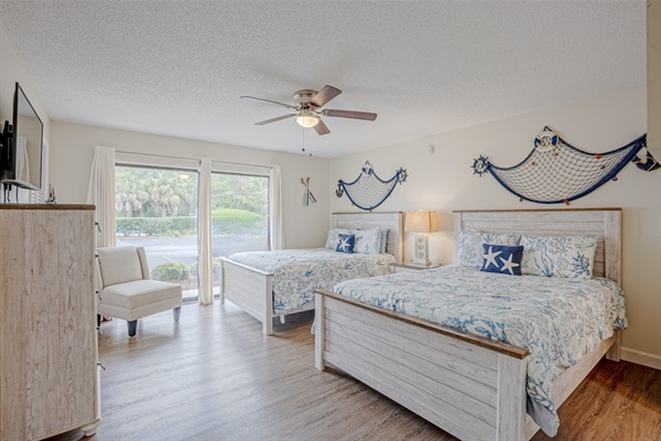 Guest bedroom with two queen beds, ceiling fan, and smart TV